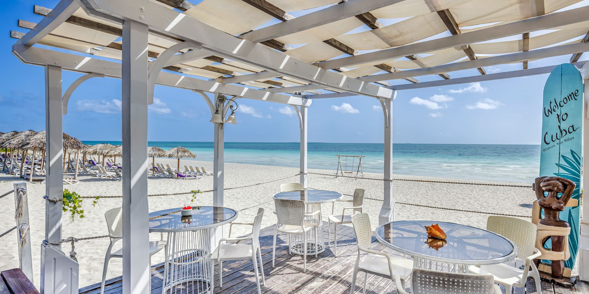 a white table and chairs on a beach