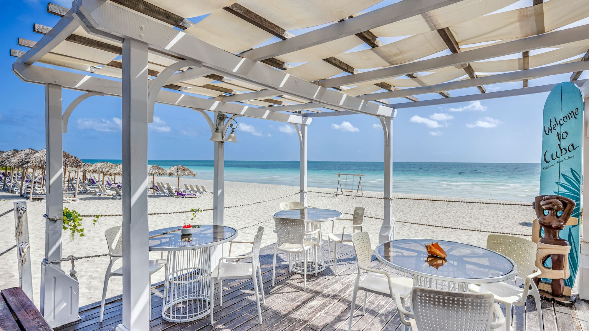 a white table and chairs on a beach