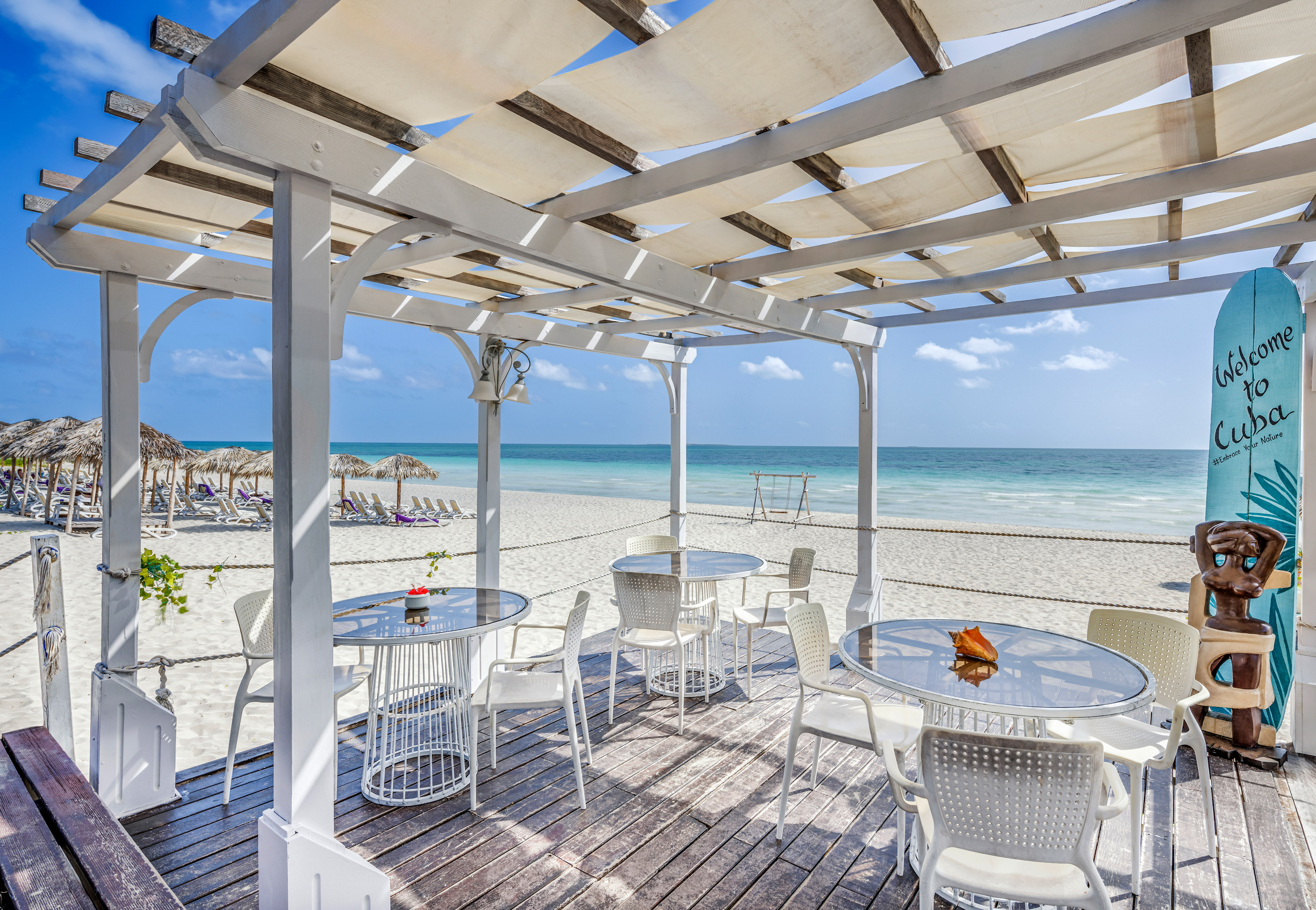 a white table and chairs on a beach