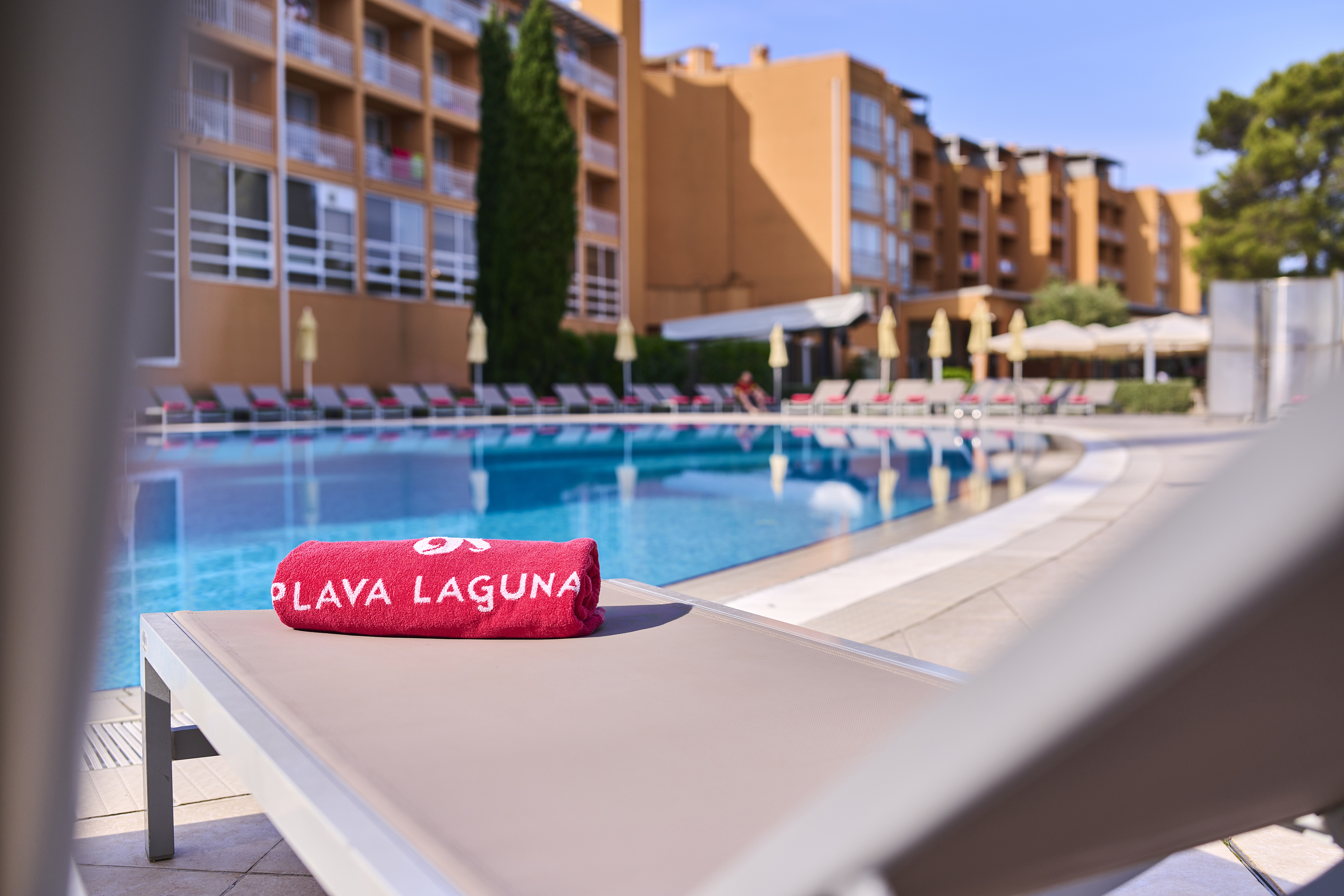 a towel on a lounge chair by a pool