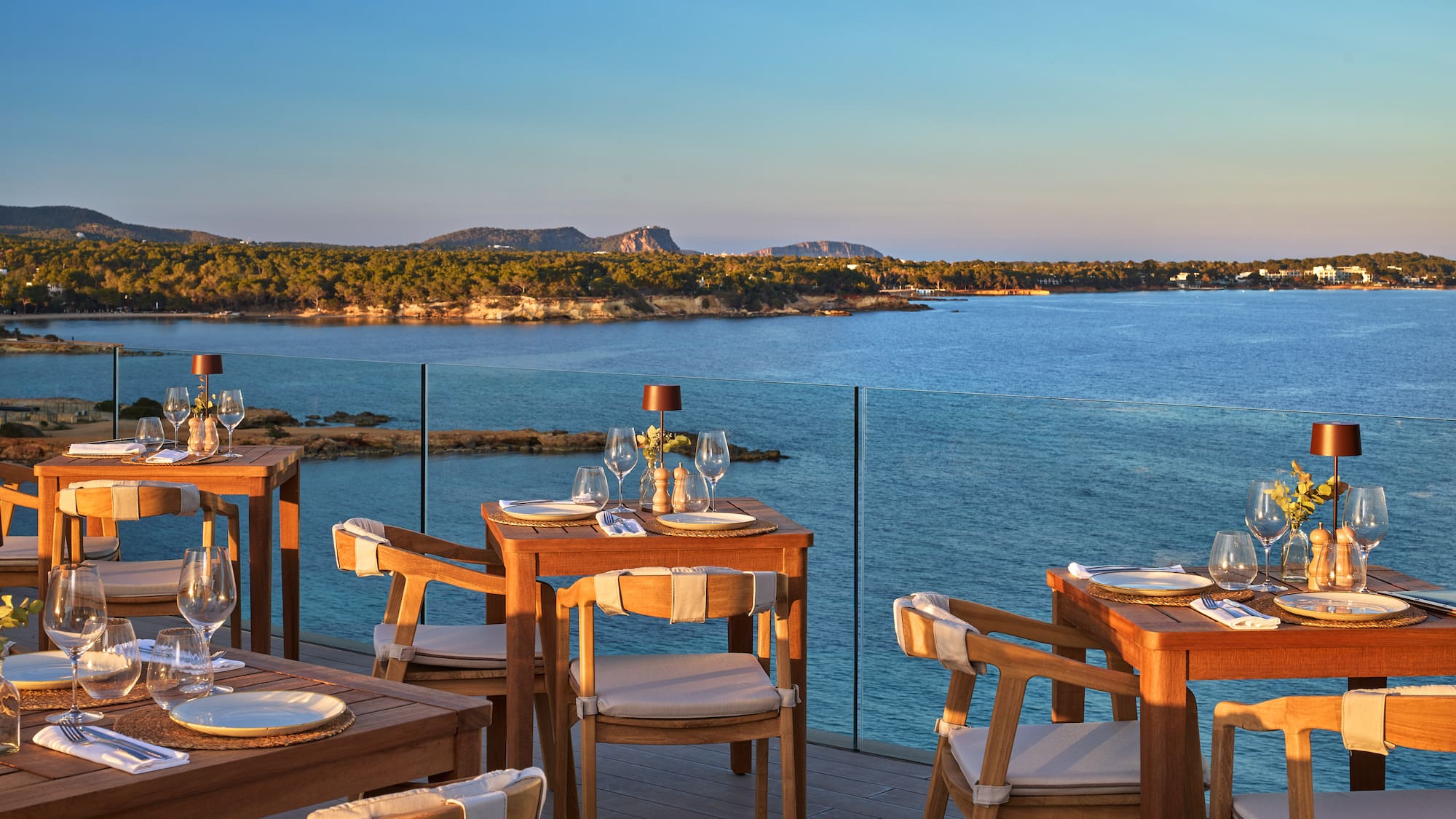 a table and chairs on a deck overlooking a body of water