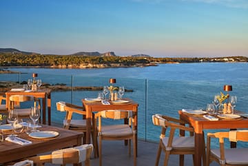 a table and chairs on a deck overlooking a body of water
