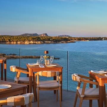 a table and chairs on a deck overlooking a body of water