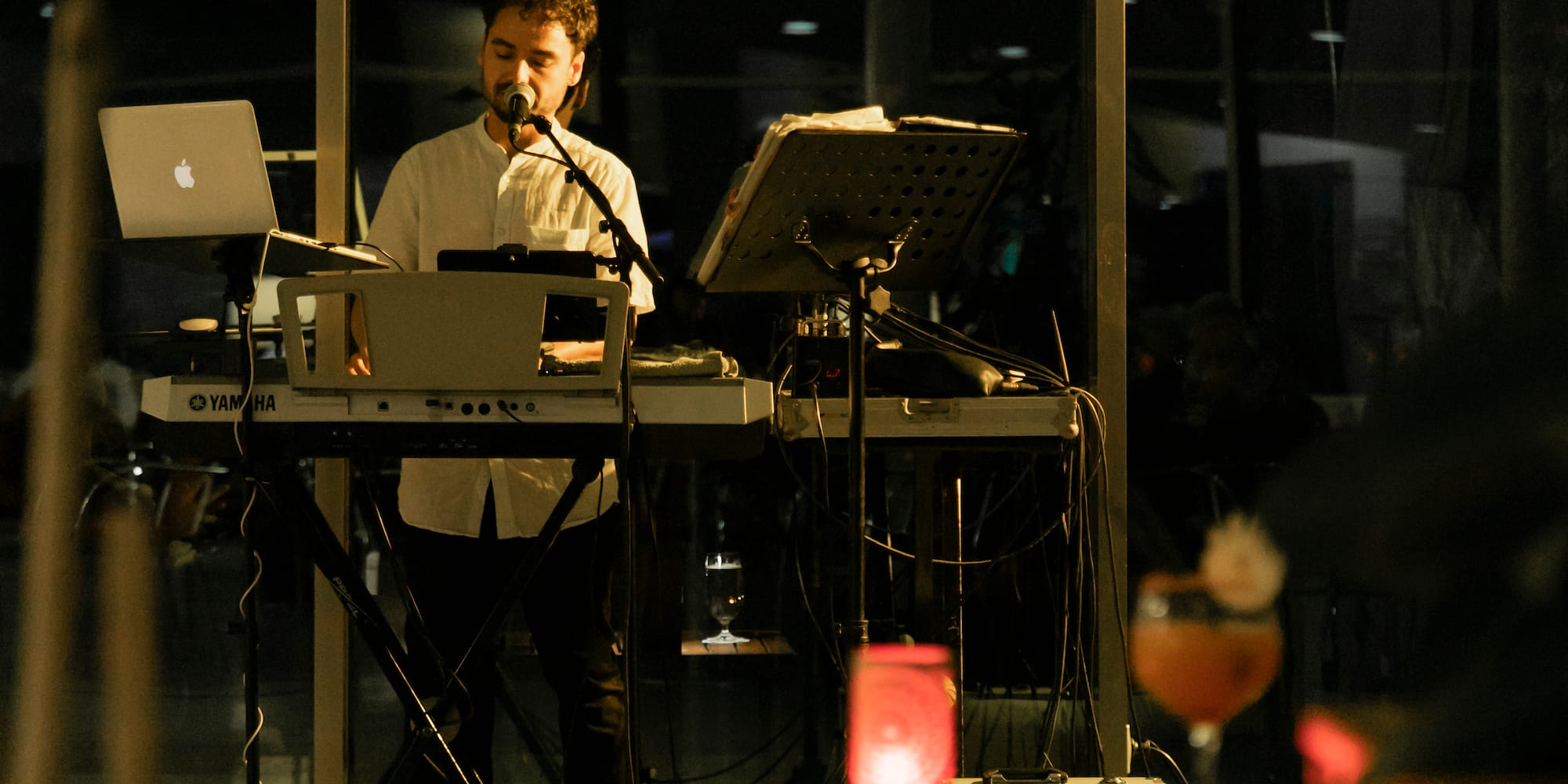 a man playing piano and singing into a microphone