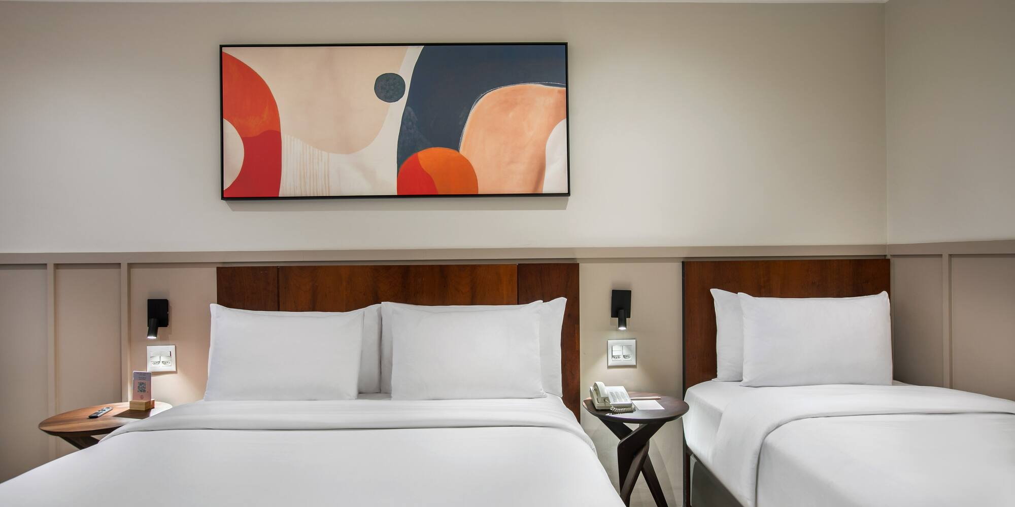 a room with two beds and a painting on the wall