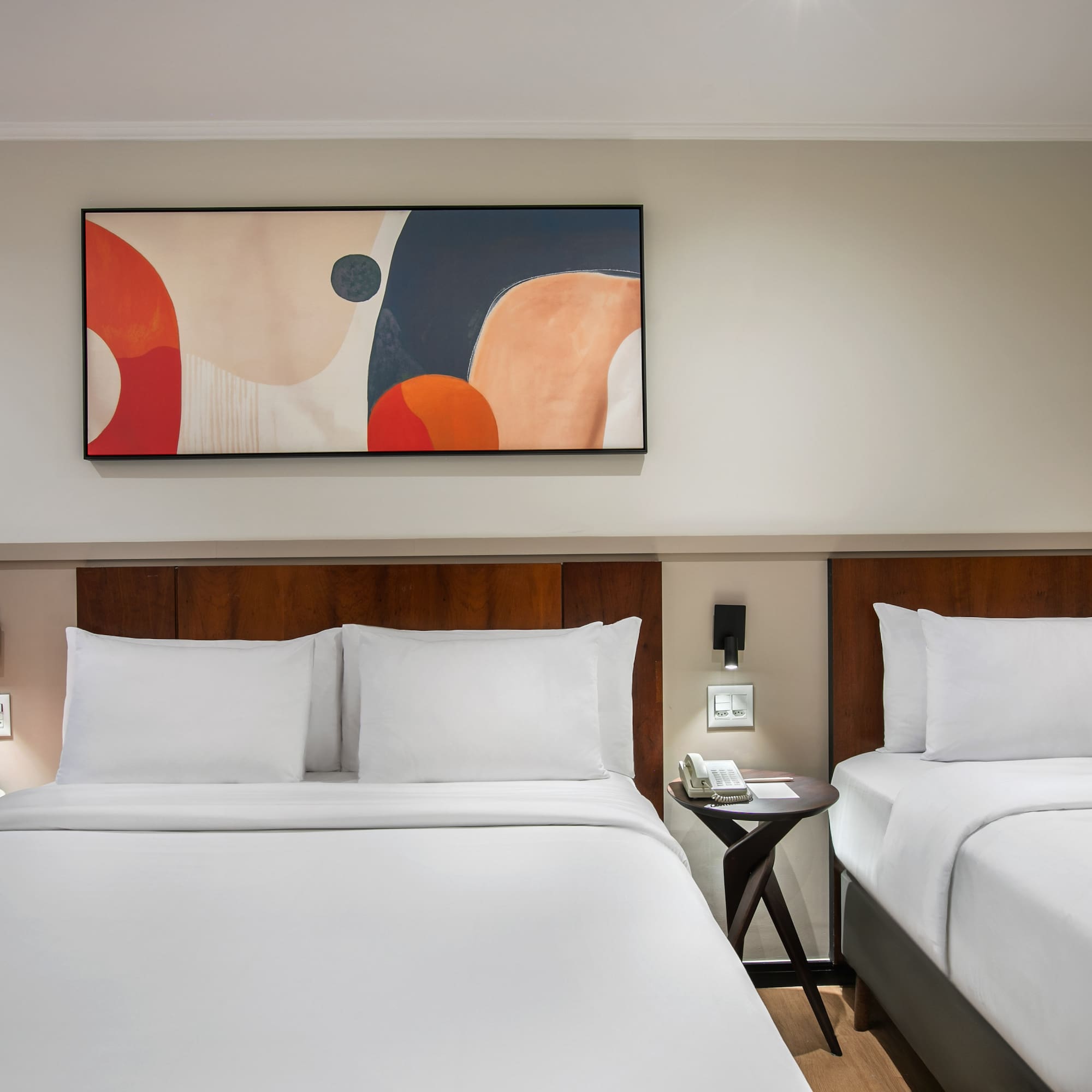 a room with two beds and a painting on the wall