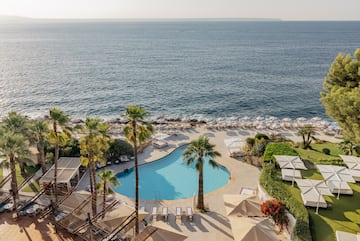 a pool with palm trees and a beach.