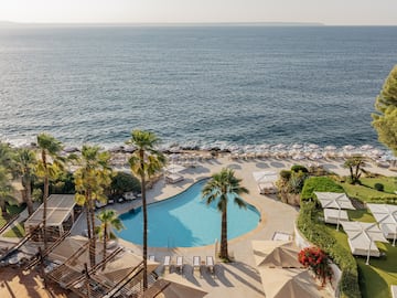 a pool with palm trees and a beach.