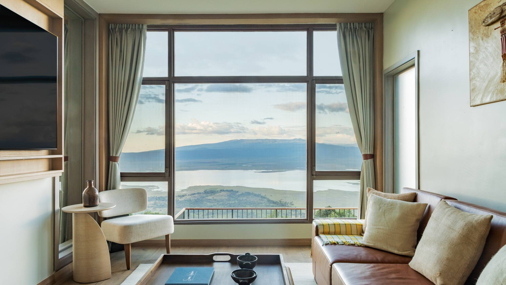 a living room with a view of a lake and mountains