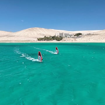 a pair of windsurfers in the water