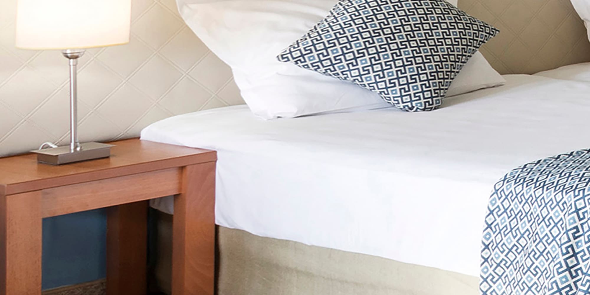 a bed with pillows and a lamp