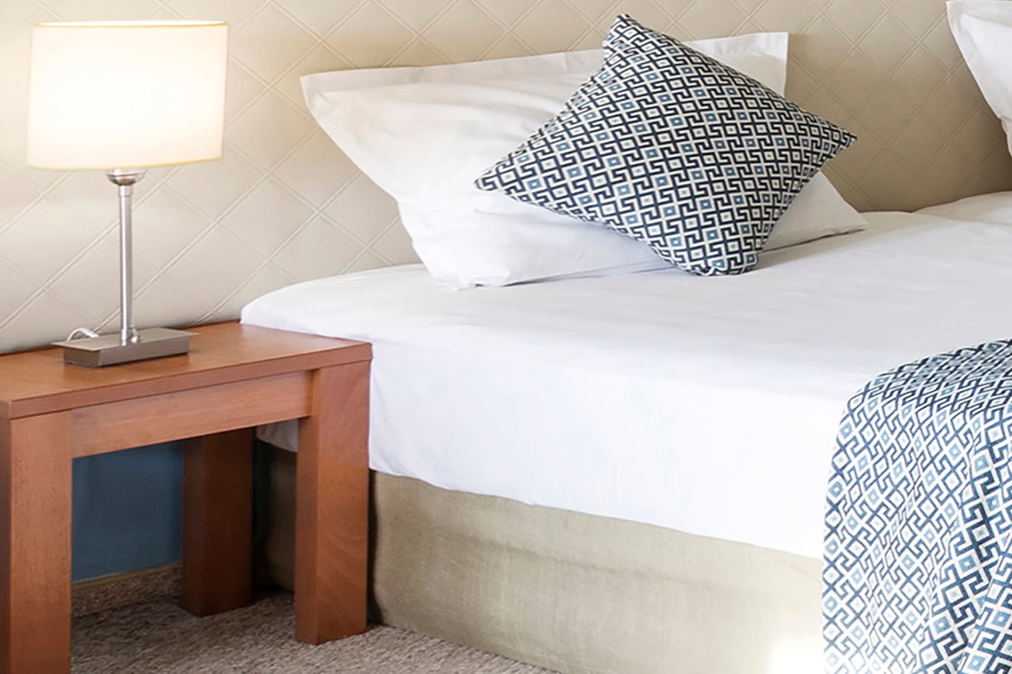 a bed with pillows and a lamp