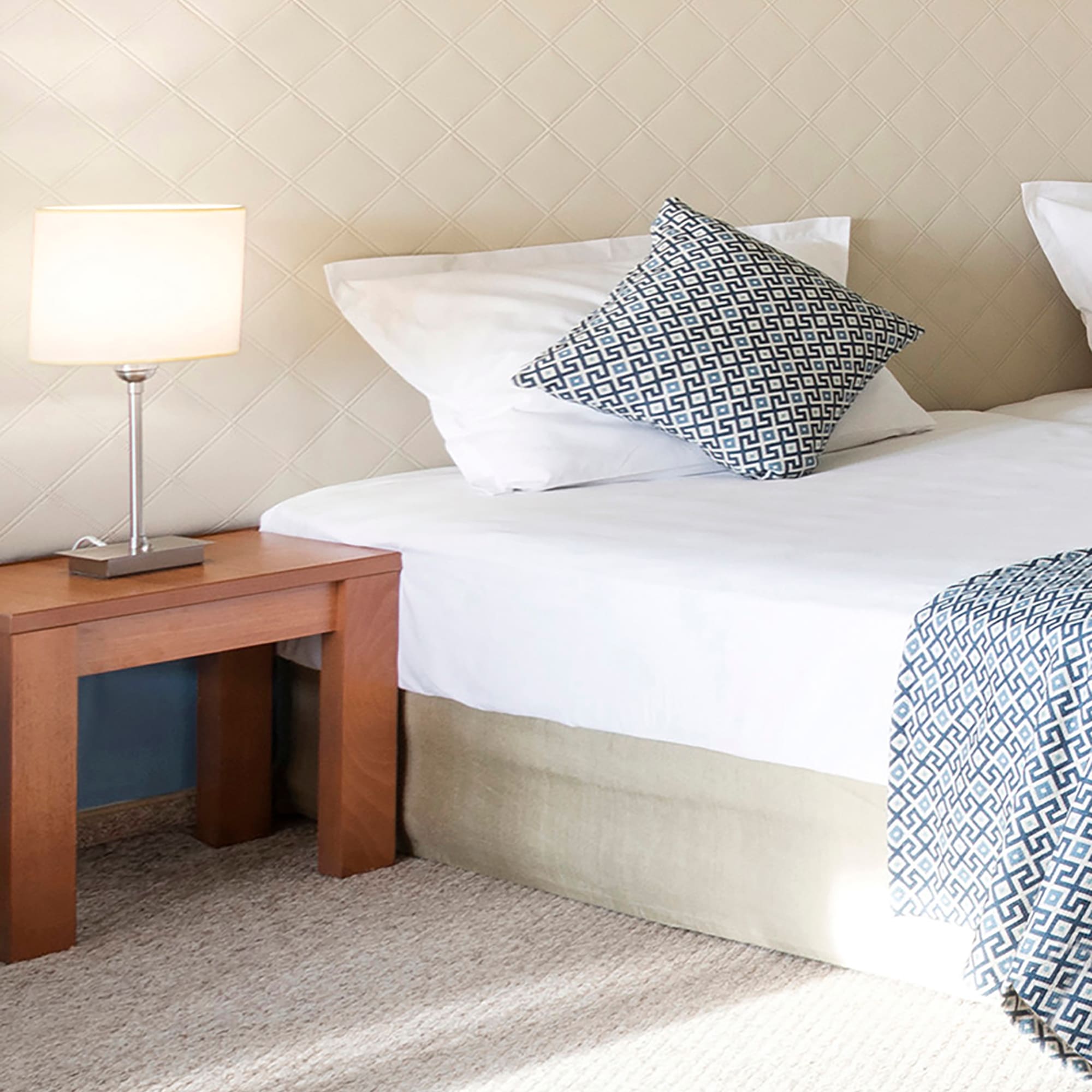 a bed with pillows and a lamp