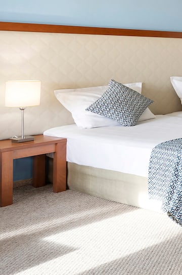 a bed with pillows and a lamp