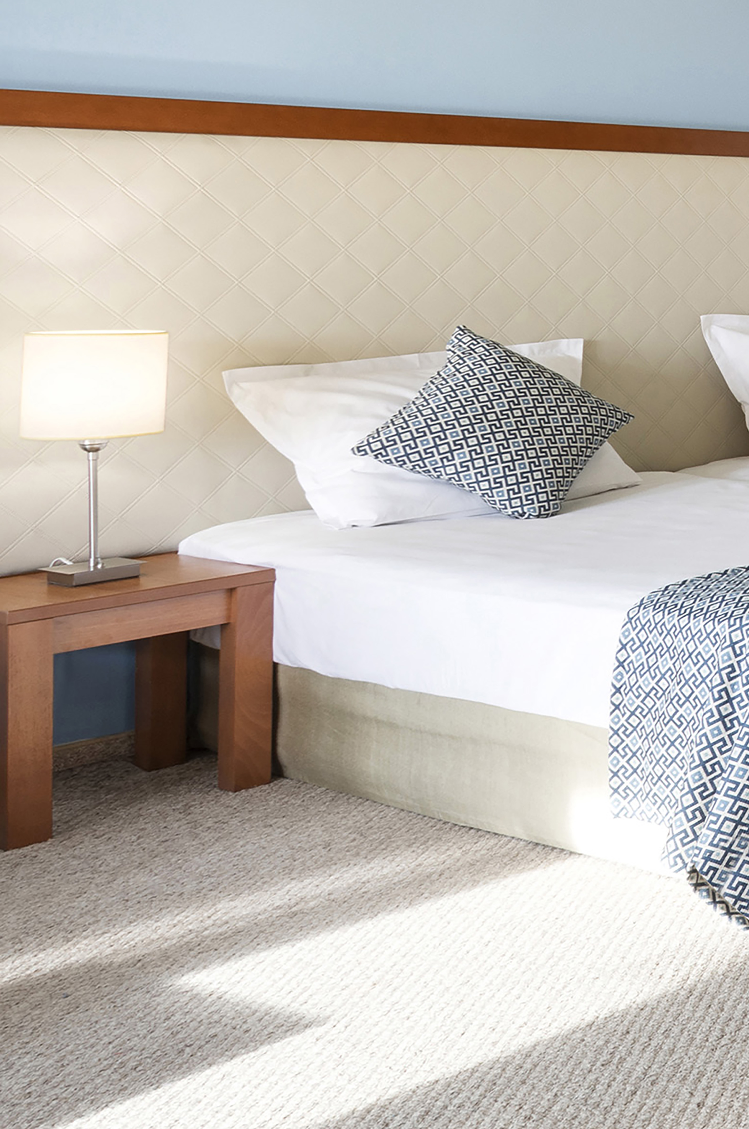 a bed with pillows and a lamp