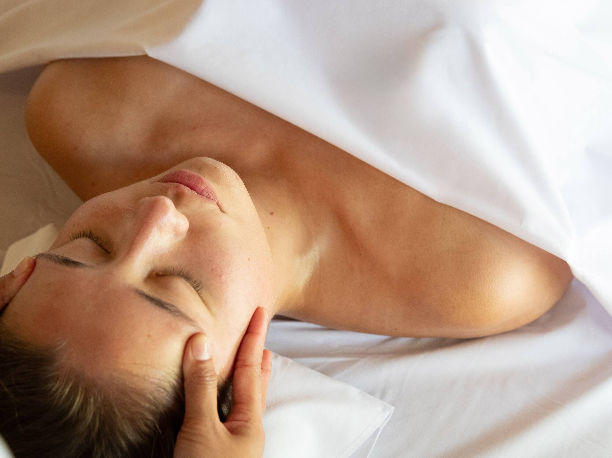 a woman lying down with her eyes closed