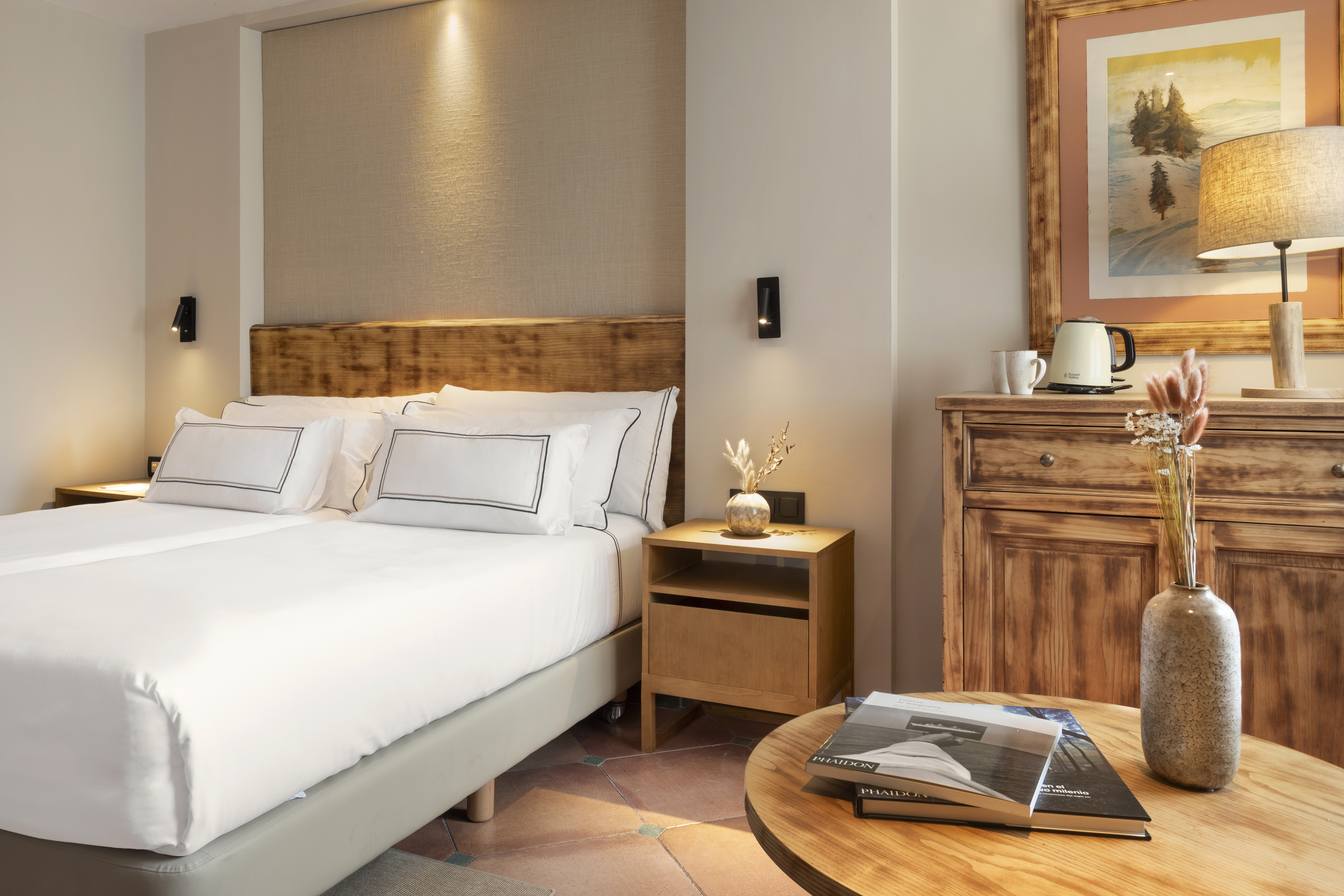Cozy hotel bedroom with double bed, wooden furniture, and warm lighting.