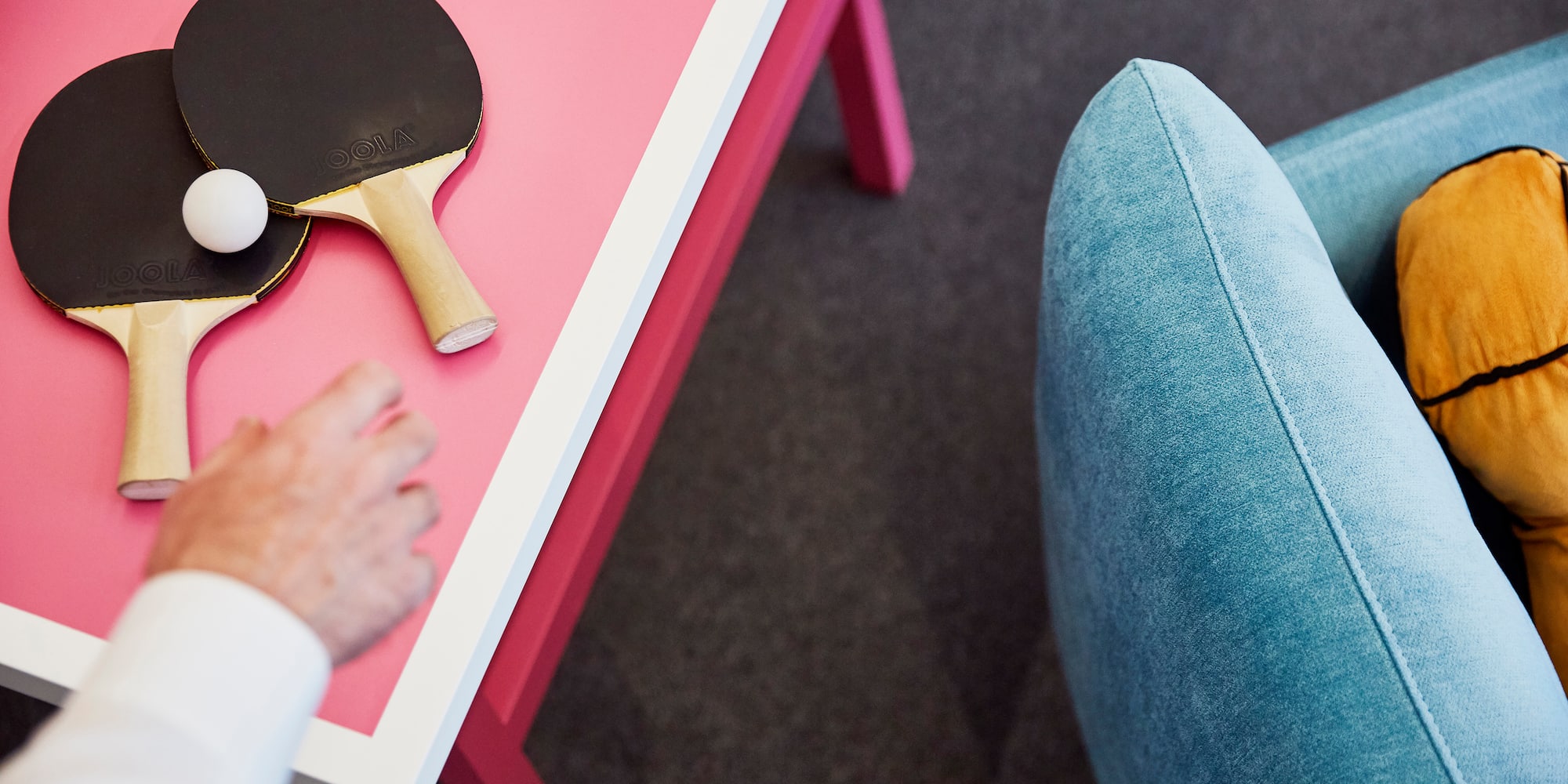 a person's hand on a table with a ping pong paddle