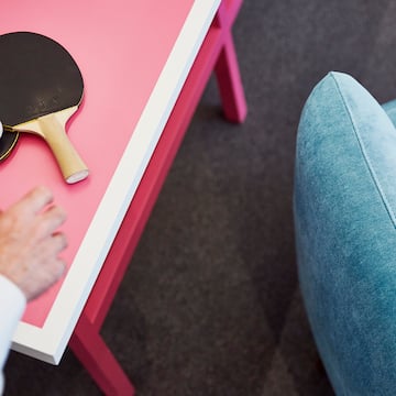 a person's hand on a table with a ping pong paddle