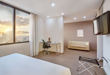 a room with a bed and a couch and a window