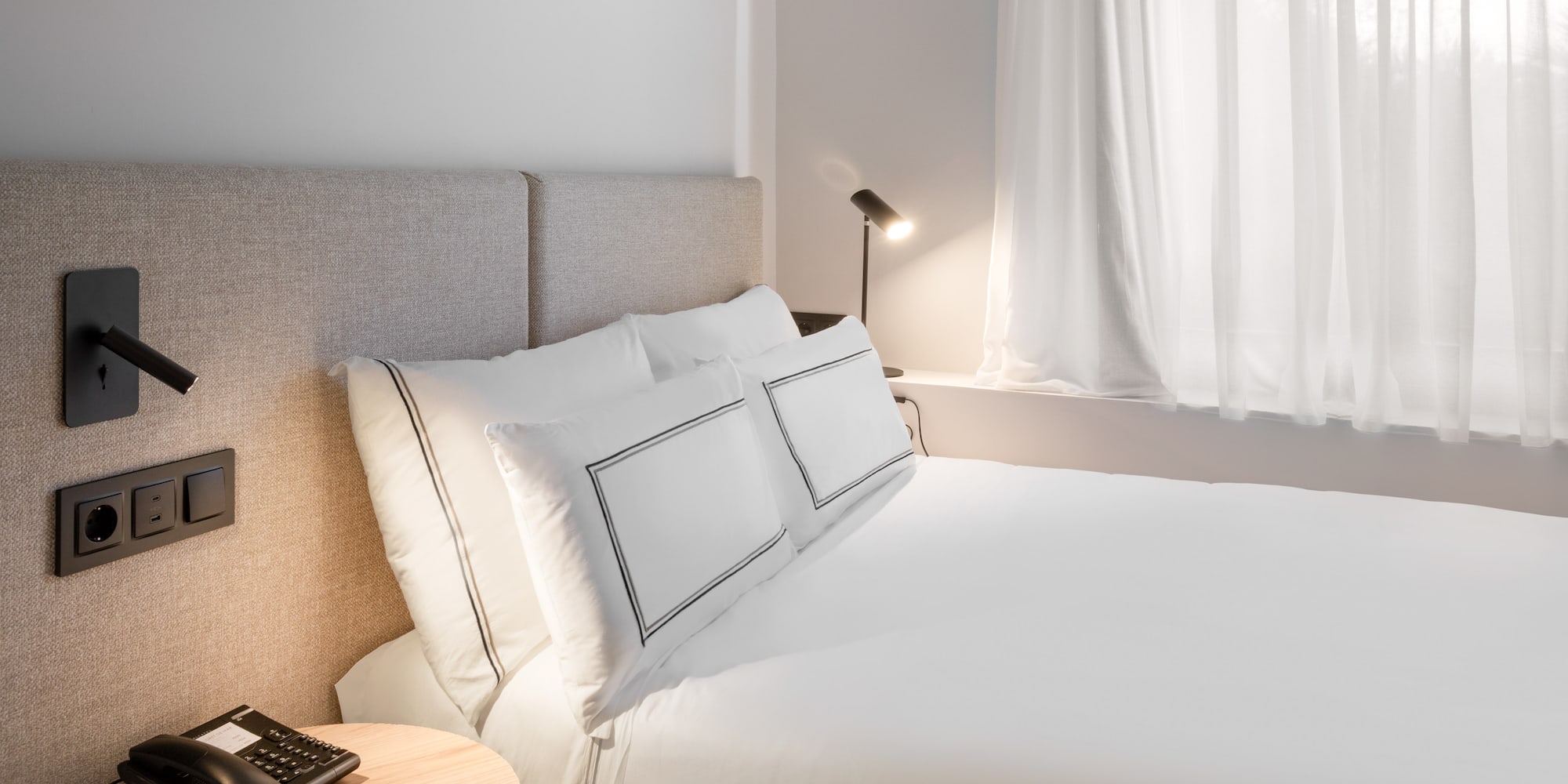 a bed with a lamp and a table