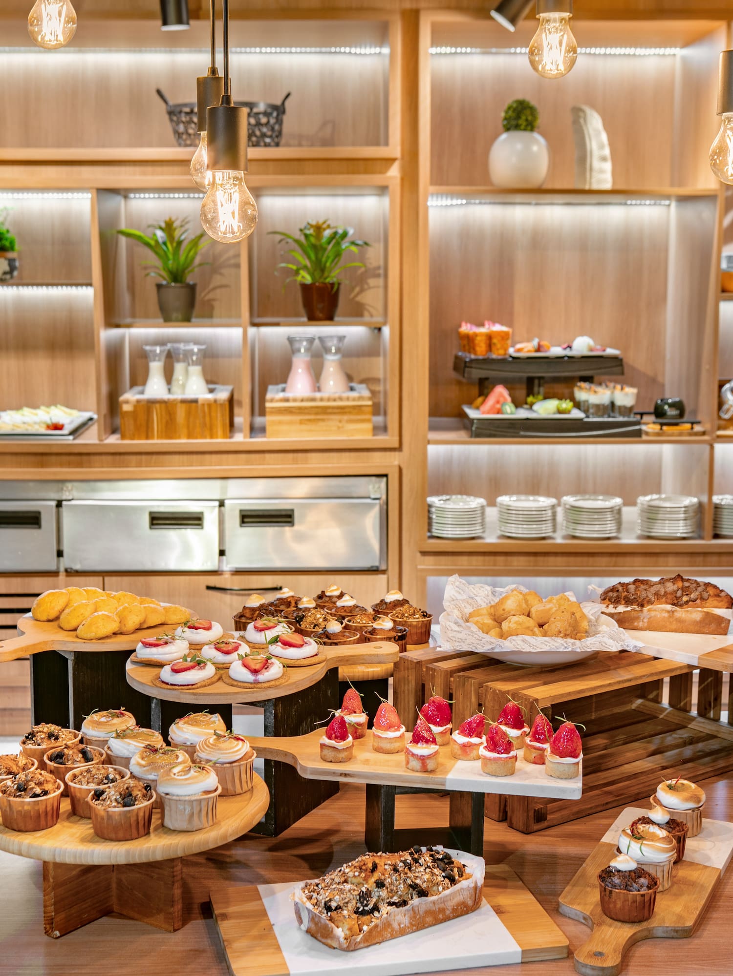 Dessert buffet with cupcakes, strawberry tarts, muffins, and assorted pastries.