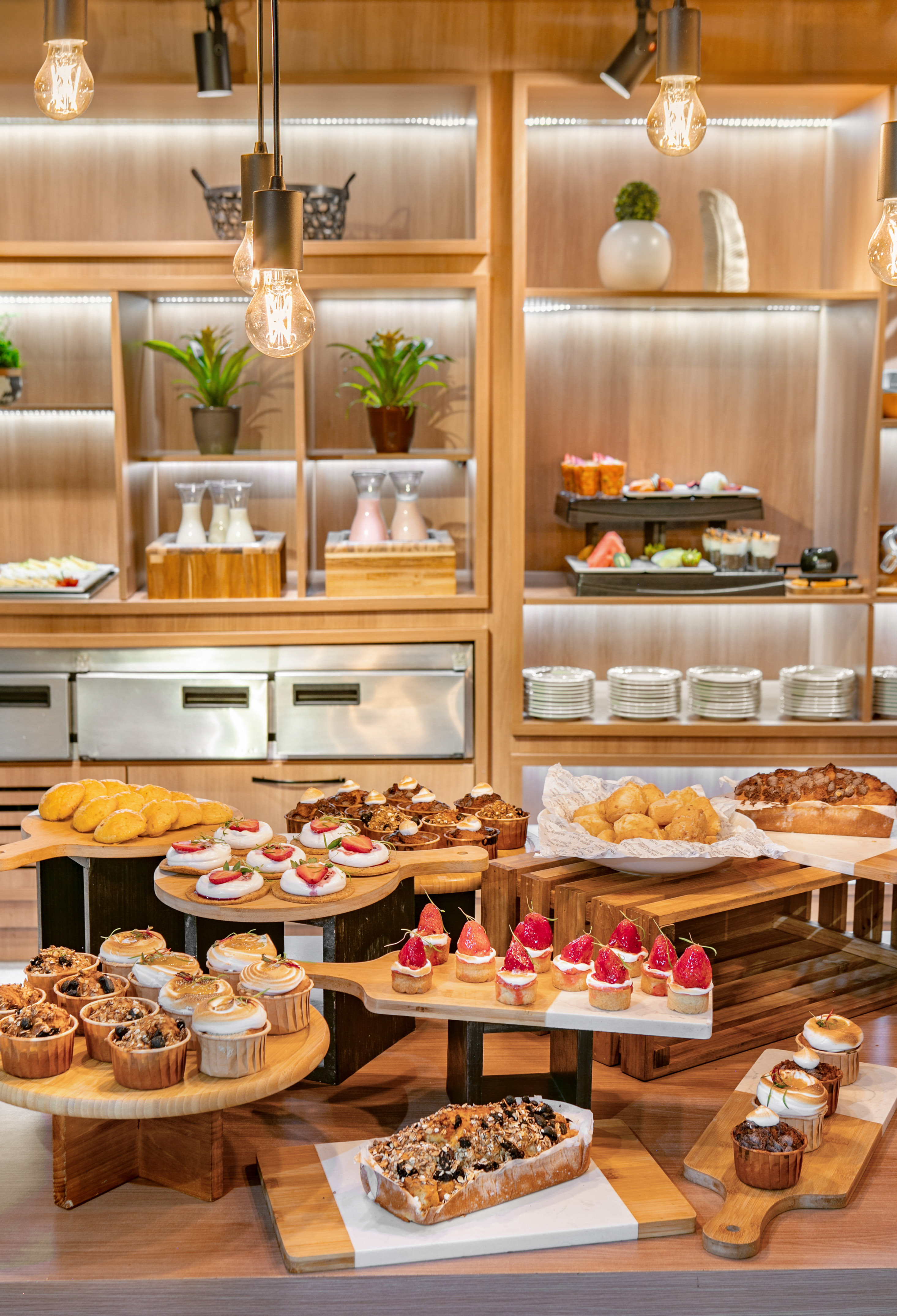 Dessert buffet with cupcakes, strawberry tarts, muffins, and assorted pastries.
