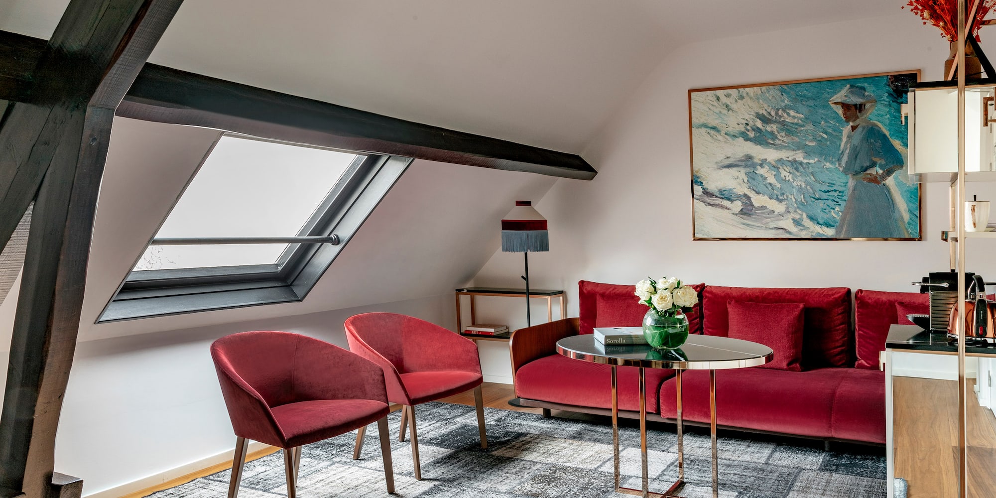 a room with a red couch and chairs