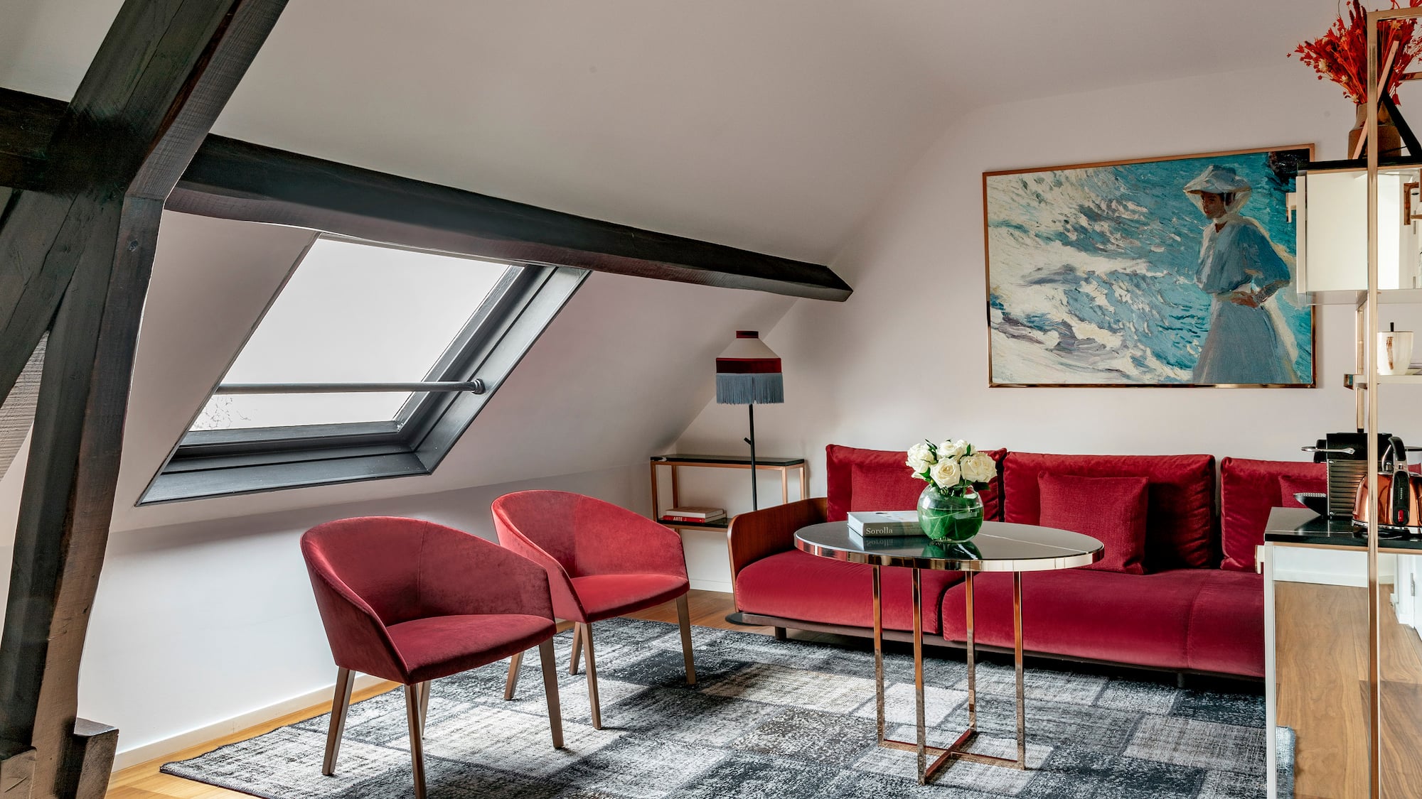 a room with a red couch and chairs