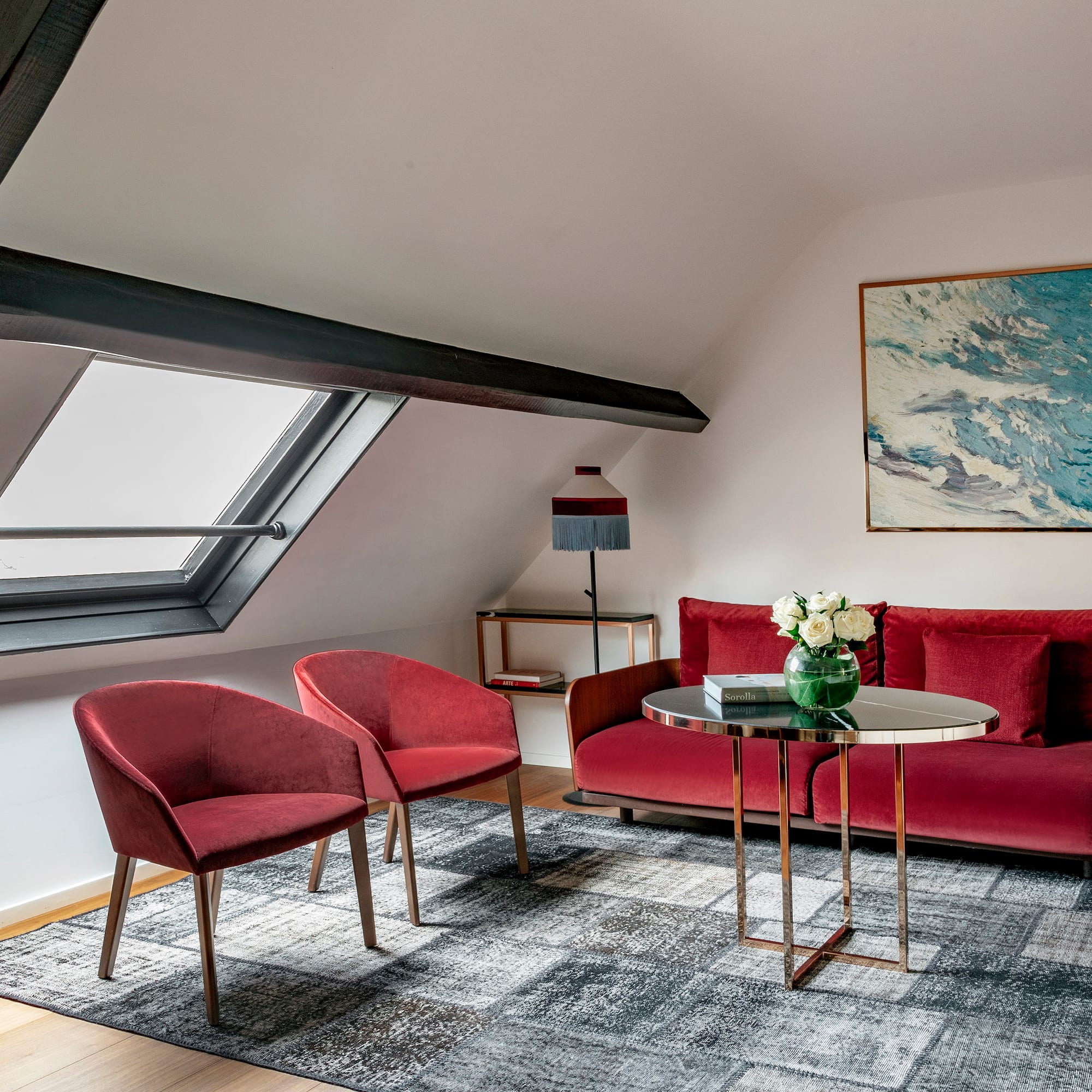 a room with a red couch and chairs