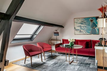 a room with a red couch and chairs
