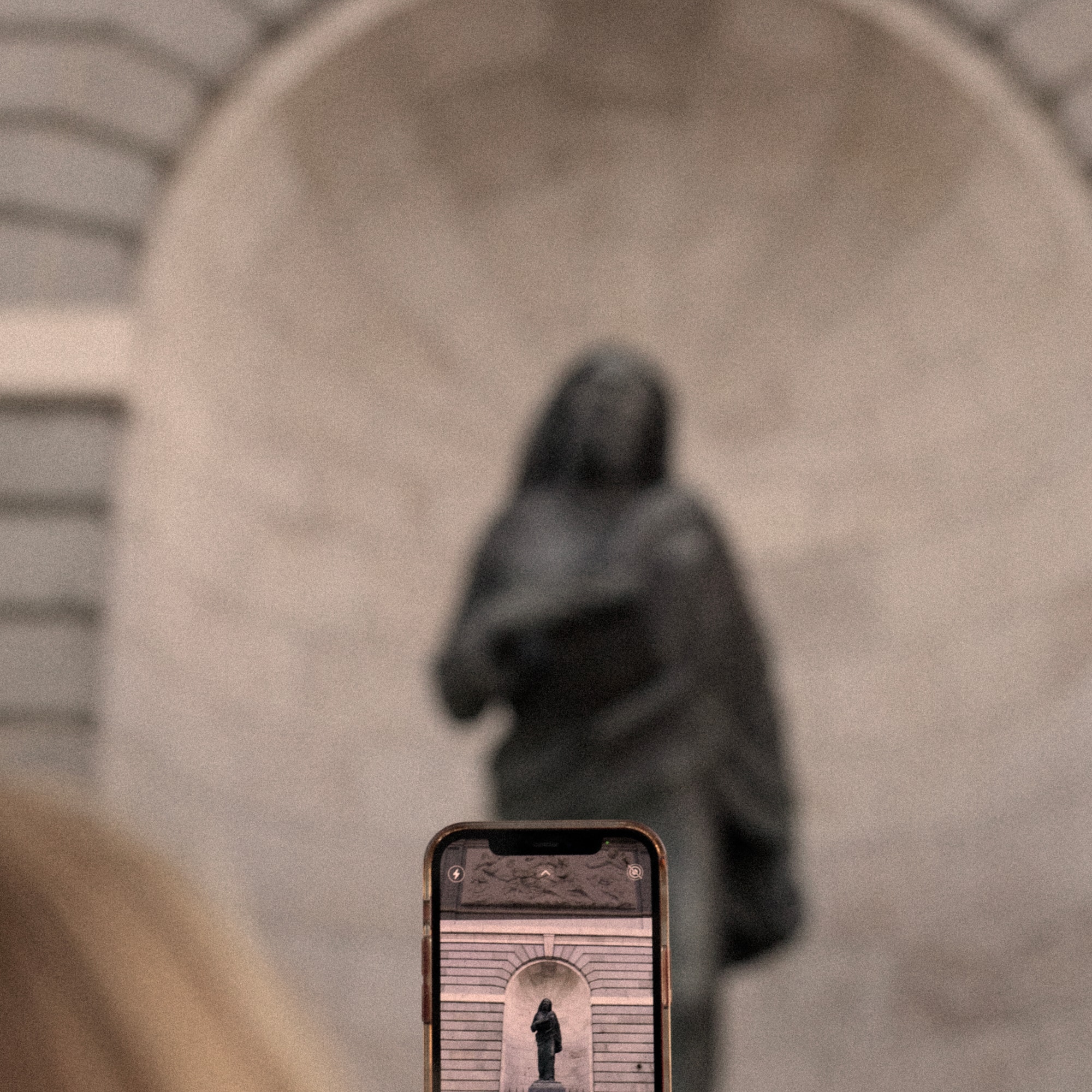 a phone with a keyhole in front of a statue