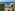Beachfront resort aerial: Pools, water park, lush forest, blue ocean.