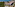 Beachfront resort aerial: Pools, water park, lush forest, blue ocean.
