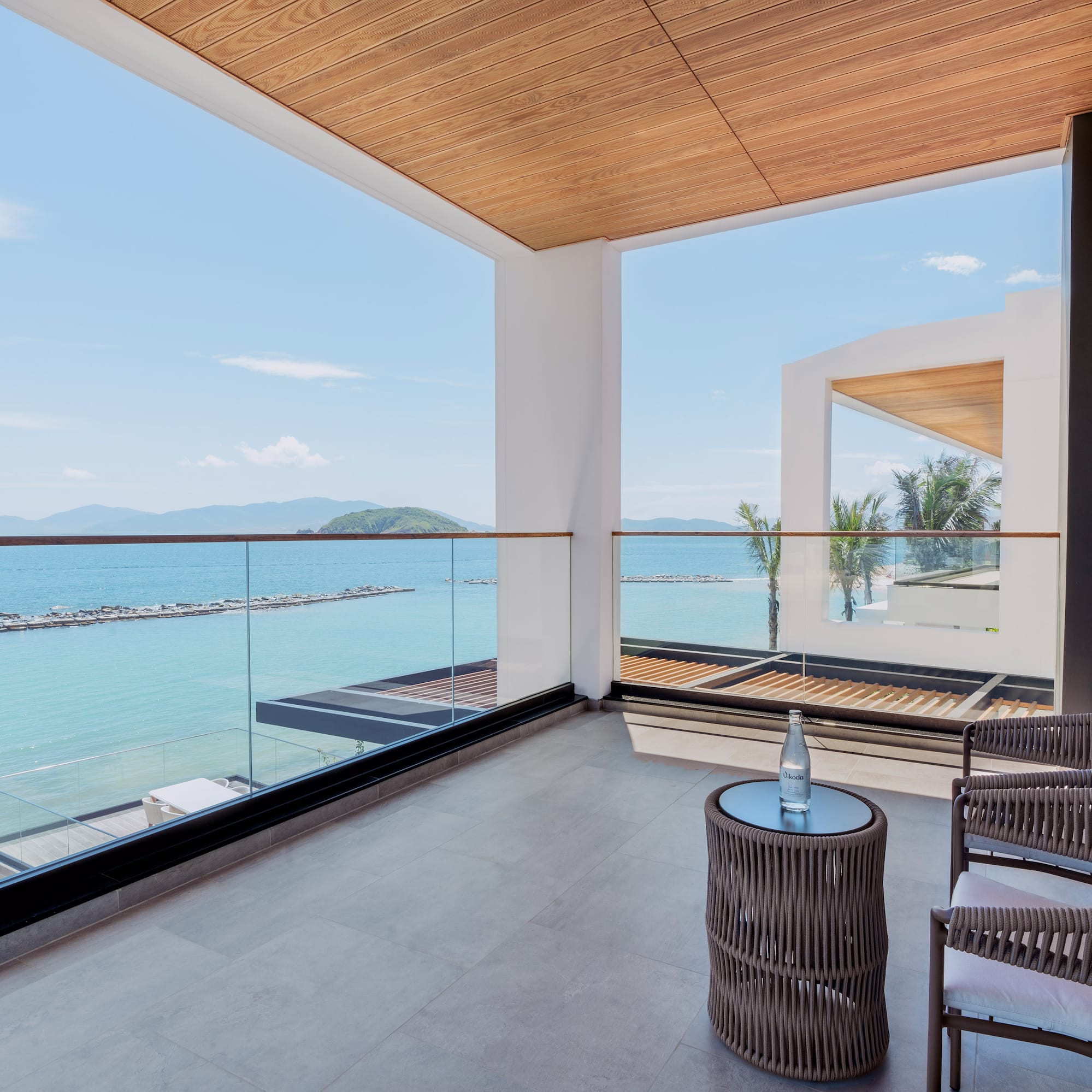 a balcony with chairs and a table overlooking water