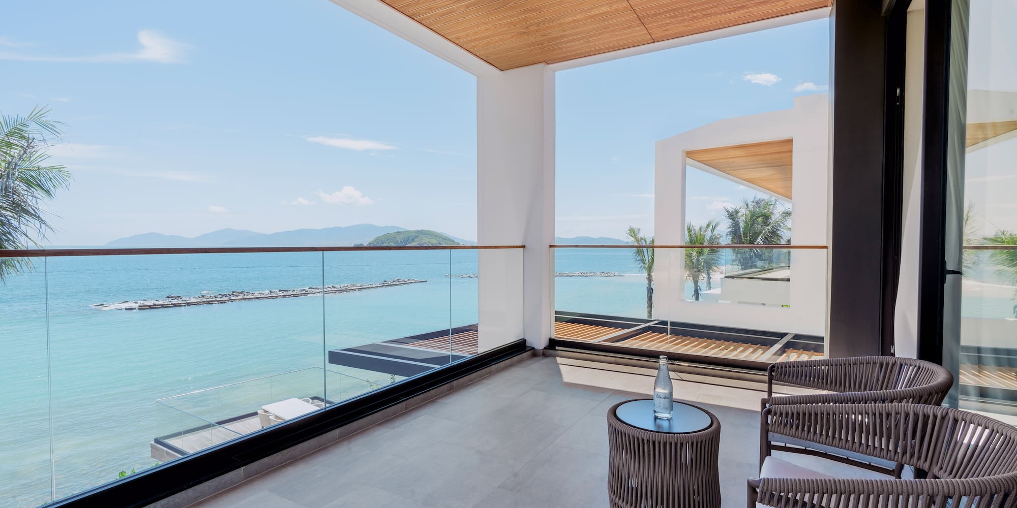 a balcony with chairs and a table overlooking water