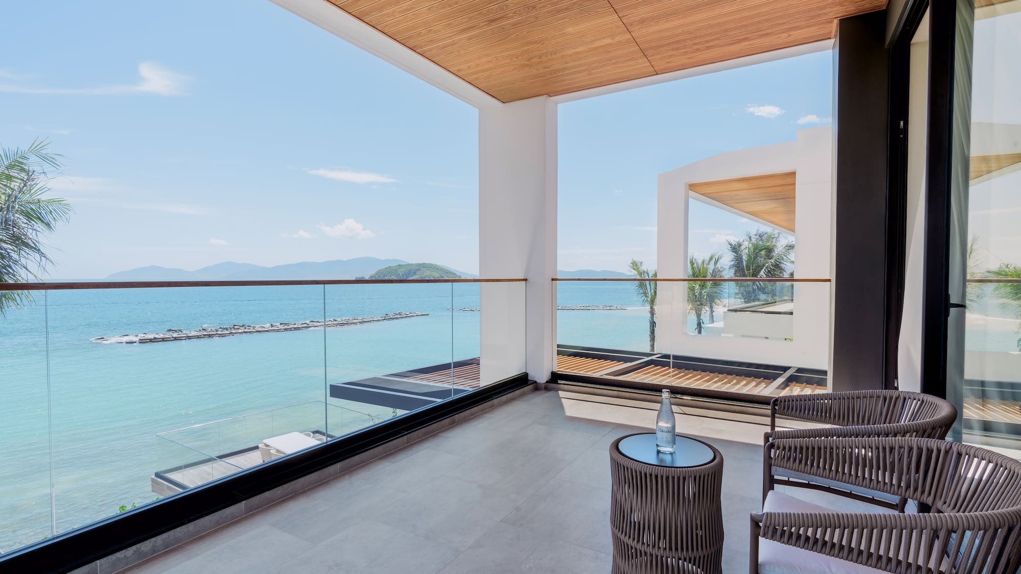 a balcony with chairs and a table overlooking water