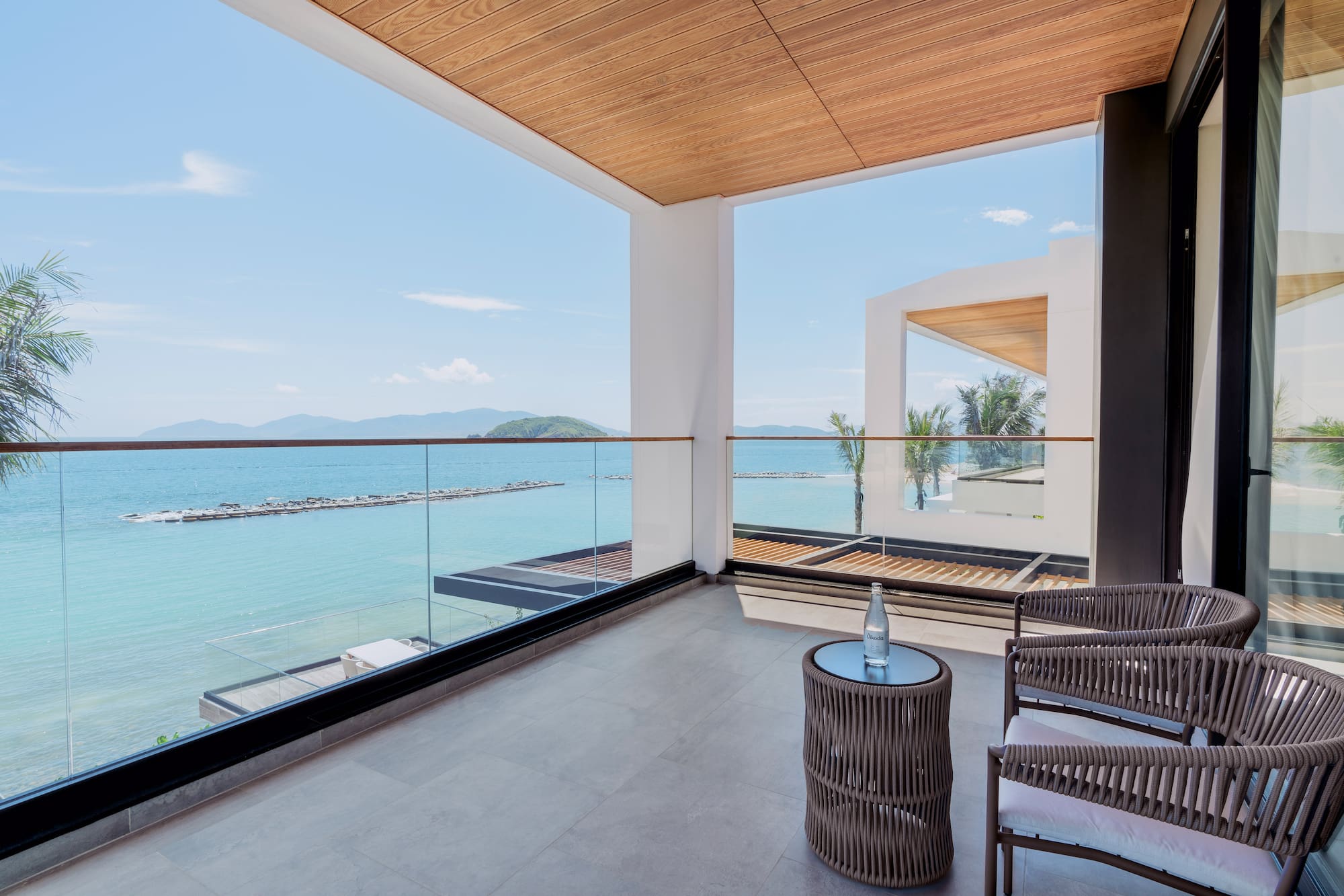 a balcony with chairs and a table overlooking water