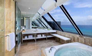 a bathroom with a large window overlooking the ocean