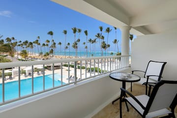 a balcony with chairs and a table and a pool
