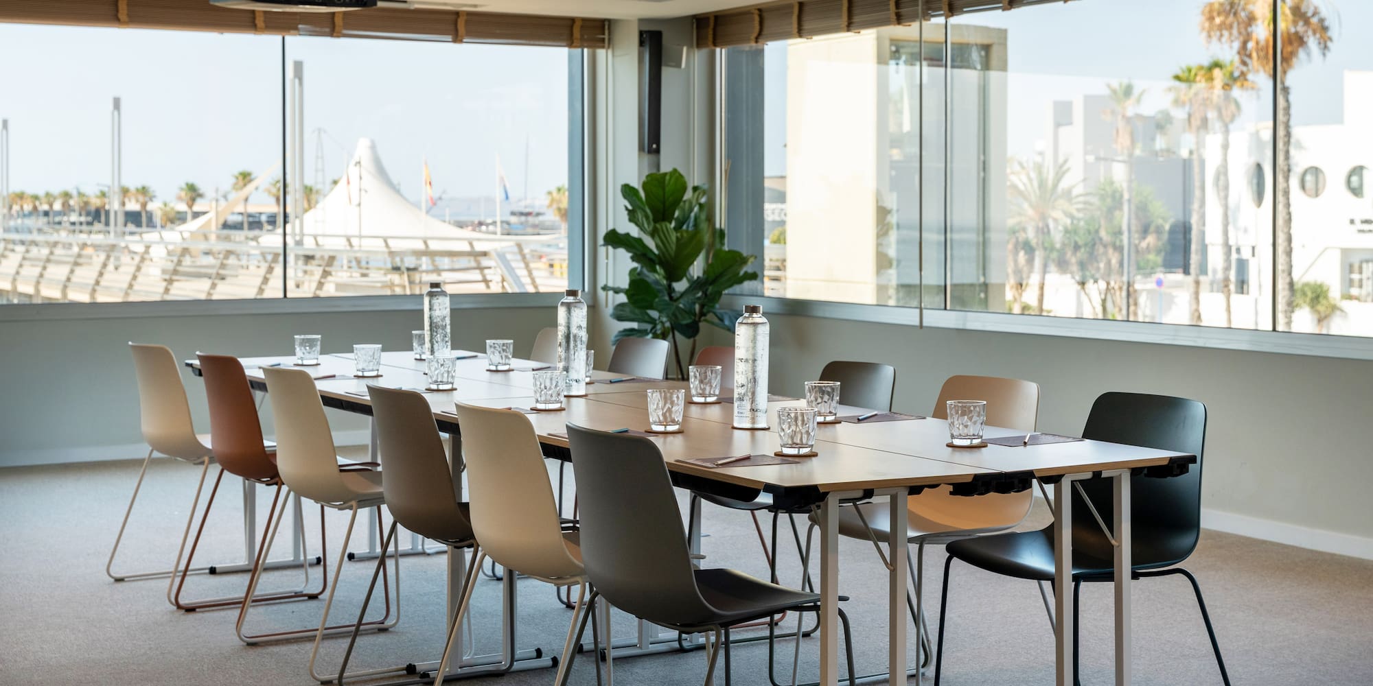 a table with chairs and water bottles in a room with windows