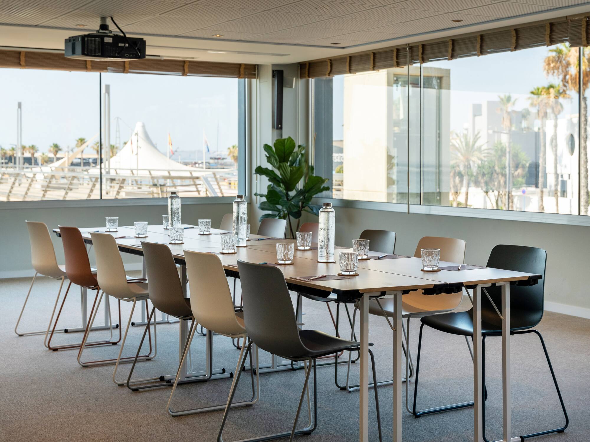 a table with chairs and water bottles in a room with windows