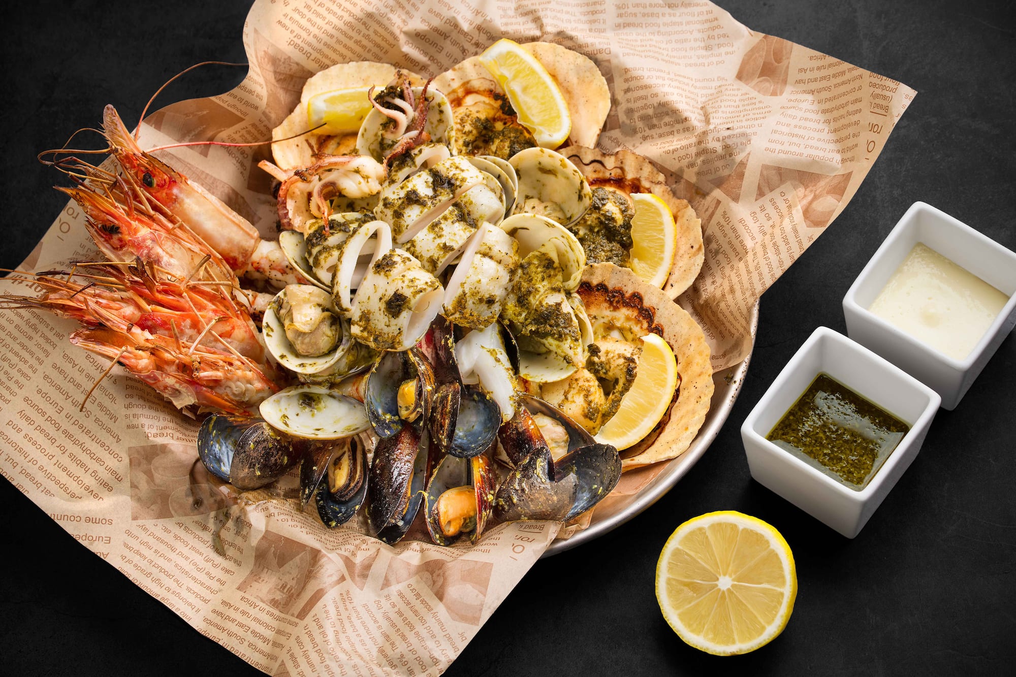 a plate of seafood with lemons and sauce