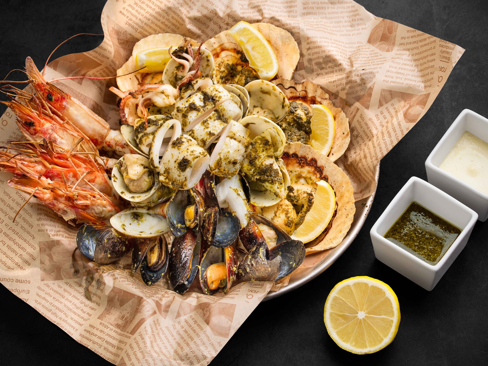 a plate of seafood with lemons and sauce