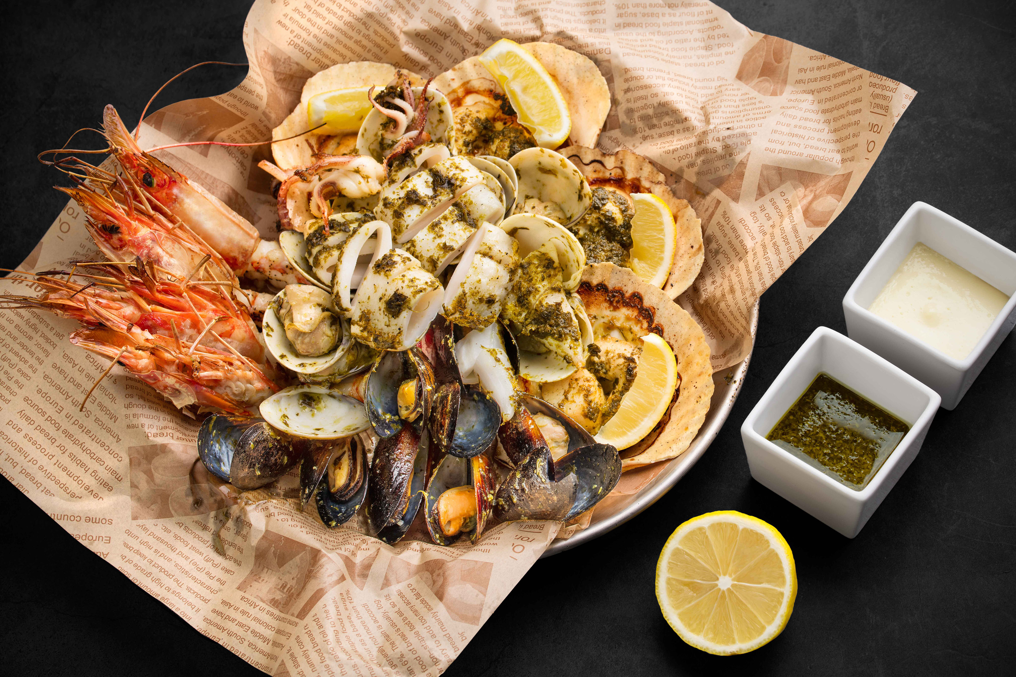 a plate of seafood with lemons and sauce