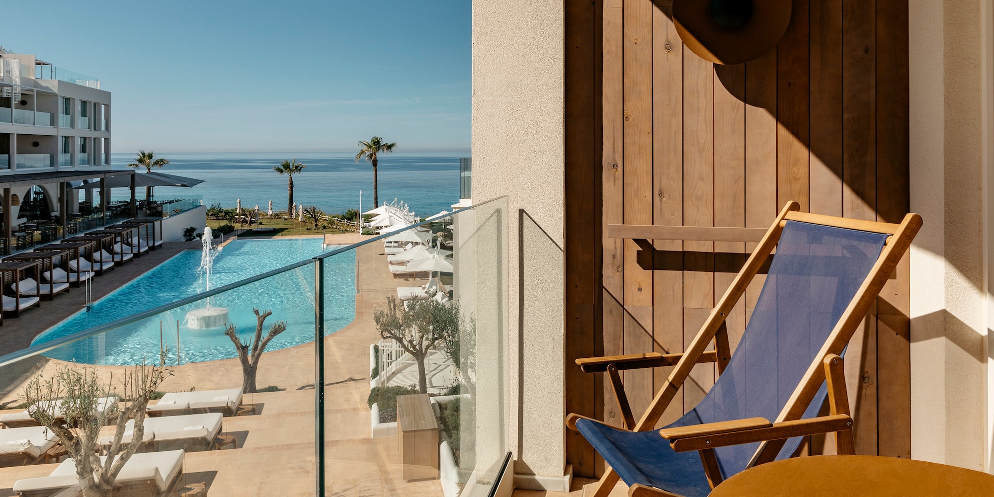a deck chair next to a pool