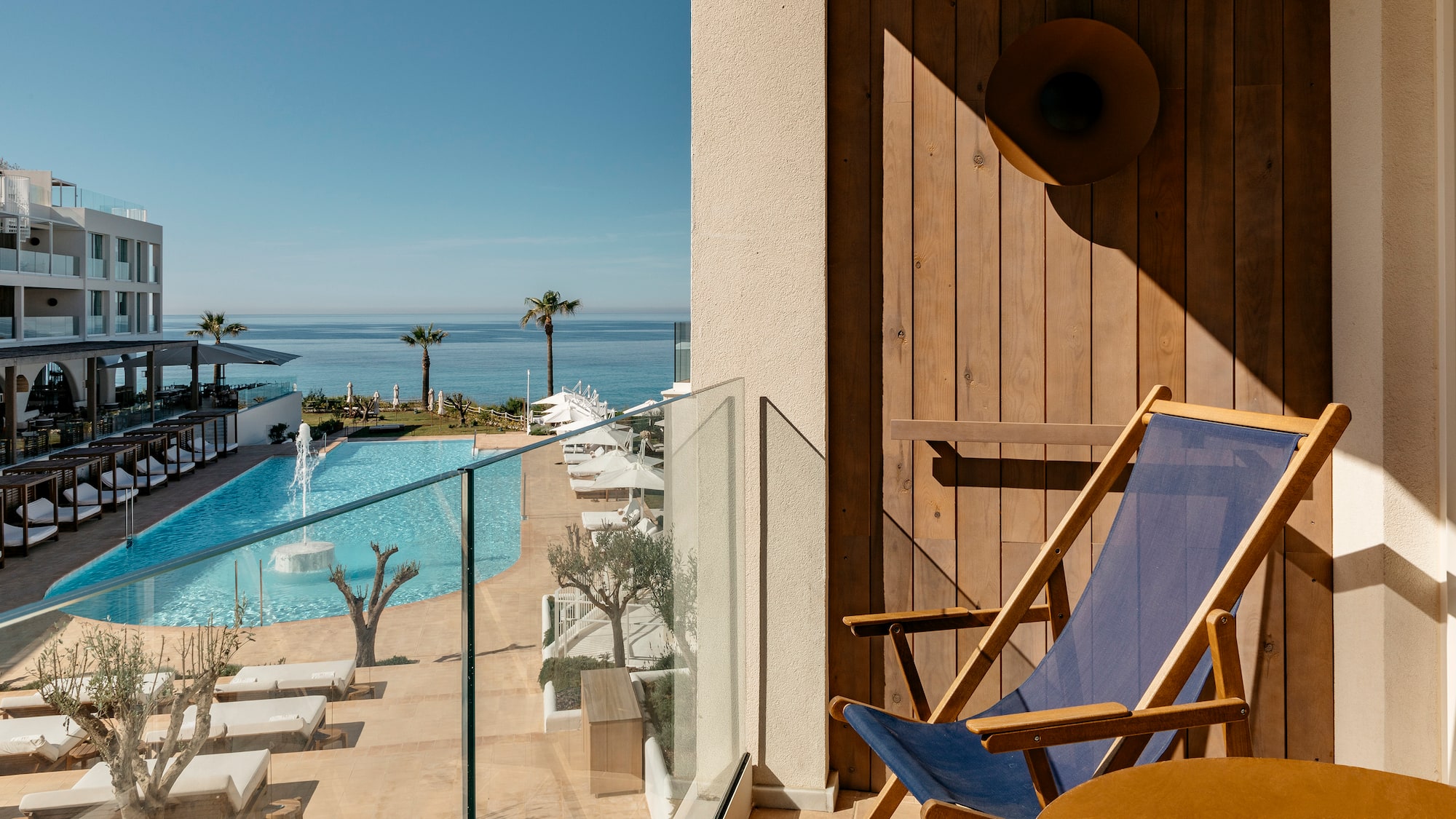 a deck chair next to a pool