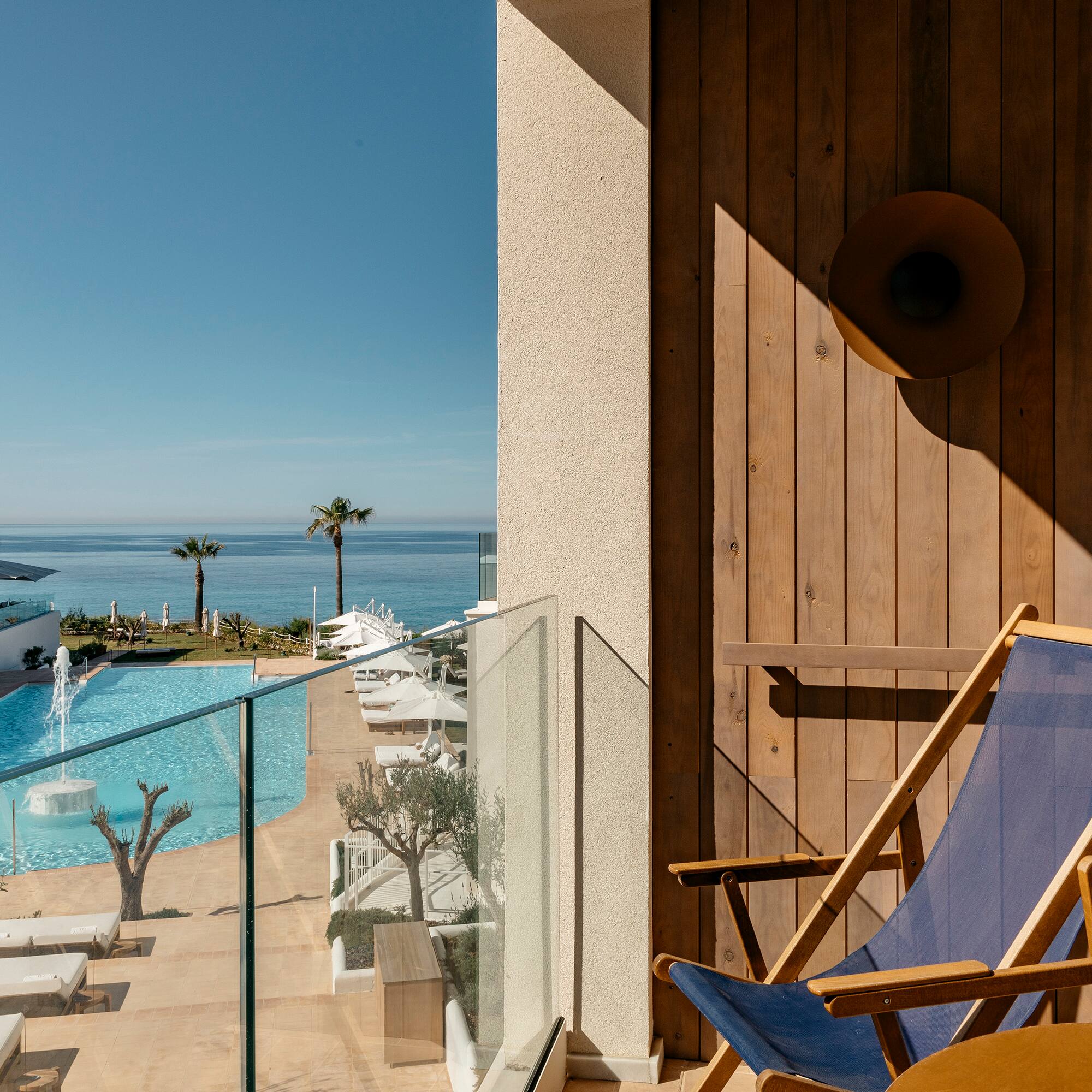a deck chair next to a pool