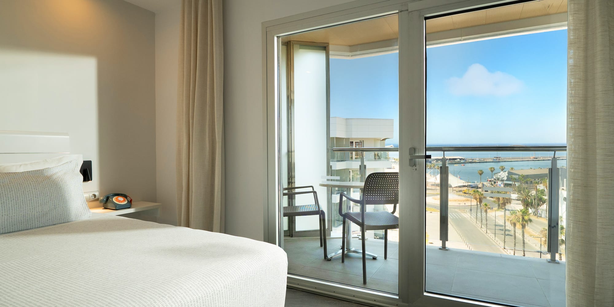 a bedroom with a glass door and a view of the ocean