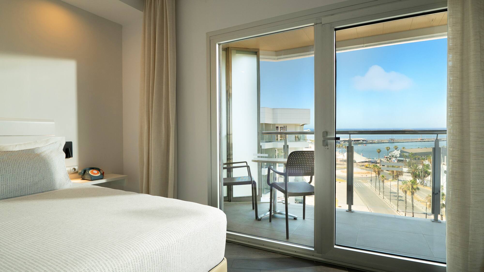 a bedroom with a glass door and a view of the ocean